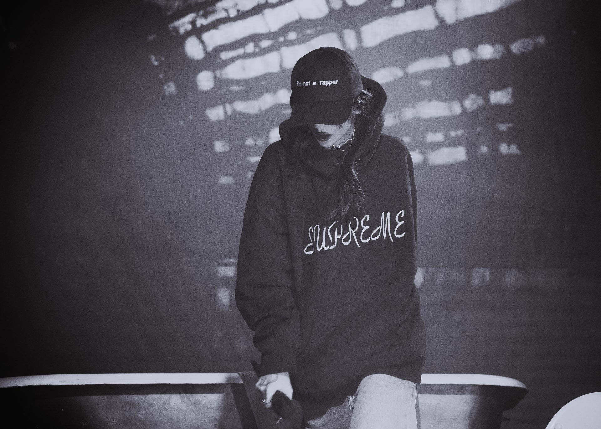 Sisi in a hooded jacket, lit by the LED stage screens