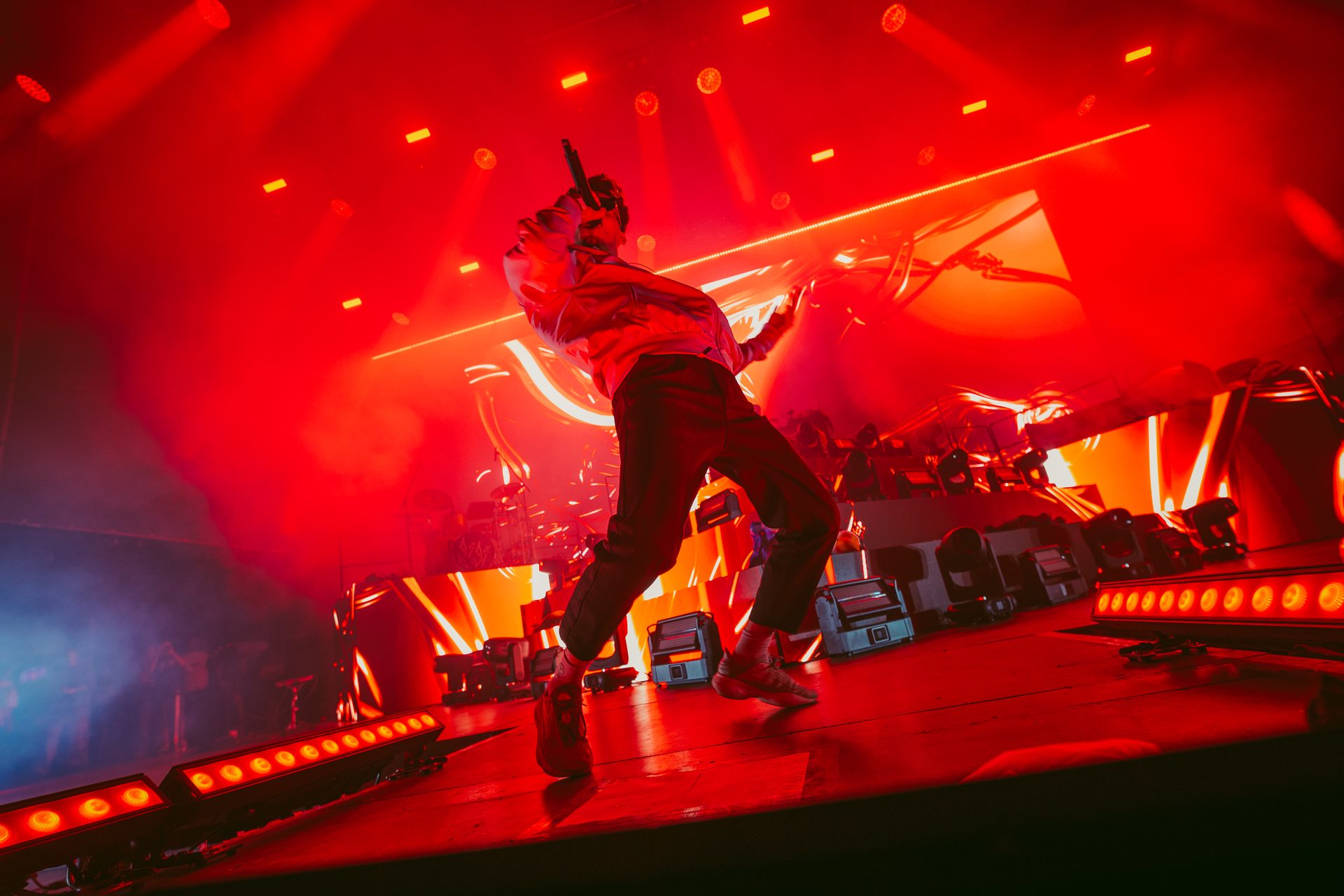 Sisi mid-performance under red stage lighting